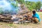 a person burns wood for a stone-fired event, a traditional Papuan cooking method, Indonesia.