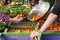 Person buying fresh tomatoes at a farm market.