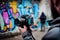 person, capturing urban graffiti art on camera, with colorful background and blurred surroundings