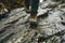 person carefully stepping on a delicate rock flake