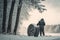 person, changing tires on wintery day, with view of snowy forest visible in the background