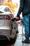 A person charging an electric vehicle at a charging station