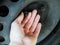 Person checking rusty nuts on a steel rim of a vehicle