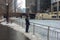 Person on Chicago riverwalk looking at icy river