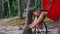 person chilling in hammock in forest and play reggae on small African hand drum