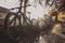 Person cleaning mountain bikes with the aid of a water jet. Panoramic dreamy photo of bicycle cleaning, strong sunlit backlight