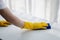 Person cleaning the room, cleaning staff is using cloth and spraying disinfectant to wipe the desk in the company office room.