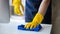 Person cleaning the room, cleaning staff is using cloth and spraying disinfectant to wipe the glass in the company office room.