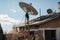 person, climbing up the roof of house, installing satellite dish for clear view of the sky