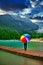 person with colorful rainbow umbrella standing in the rain