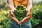 A person cradles a vibrant, green plant in the shape of the recycling emblem