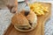 Person cuts burger in half on wooden board