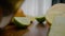 Person cuts fresh lime into pieces lying on cutting board