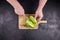 Person cuts iceberg lettuce on wooden chopping board