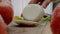 Person cuts white onion root on cutting board and removes