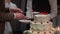 A person cutting a celebration cake. Bride and groom at wedding reception venue.