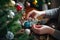 person, decorating christmas tree with variety of ornaments, including handmade ones