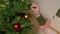 Person decorating plastic life like Christmas tree.