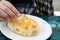 Person dipping piece of Adjarian khachapuri into egg yolk