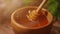 A person is dipping wooden spoon in honey. Golden fresh honey is pouring from stick. Organic beekeeping. Concept of