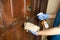 Person disinfecting door knob with disinfectant spray to kill germs, bacteria, virus