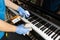 Person disinfecting piano keyboard surface with disinfectant spray to kill germs, bacteria, virus