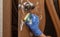 A person disinfects and cleans a gloved doorknob with a sponge and cleaning agent