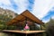 Person doing Yoga Exercise on wooden Terrace of rural Cabin