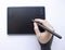 A person draws on a graphics tablet. A hand in a drawing glove holds a touch pen. A wireless graphic tablet for the designer