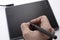 A person draws on a graphics tablet. The hand holds the touch pen. Wired graphic tablet for designer and artist.