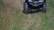 Person driving quad bike on green grass.