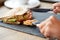 Person eating salmon panini sandwich at restaurant