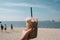 person, enjoying iced coffee latte on breezy summer day, with view of beach or park in the background