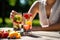 person, enjoying refreshing glass of fruit-infused water on hot summer day