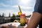 person, enjoying smoothie or shake on hot day, with view of sunny outdoor scene