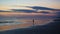 Person enjoying a solitary stroll on a tropical Canggu Bali Beach at sunset