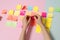 A person excitedly arranging colorful sticky notes to create a visual representation of their savings goals.. AI