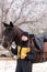 Person feeding apple to horse in snowy setting