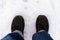 Person feet in winter shoes standing on snow