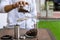 Person filling coffee beans in glass bottle beside Coffee grinder