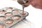 Person filling cupcake tray with batter