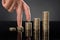 Person Finger Walking Up Over Stack Of Coins