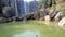 Person fishes from lifebuoy opposite foamy waterfall