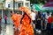 Person in flamboyant costume pass by city street full of people at dominican carnival