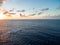 Person flying a parachute over the calm ocean during sunrise in Kitesurfing. Bonaire, Caribbean