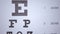 Person focusing on eyechart during sight testing, patient POV, blindness risk