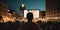 Person gazing at an open-air film screening, where a city building serves as the backdrop for a classic summer movie