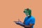 Person gesture with frog mask with a notebook and pen to write down and study back-to-school classes concept on orange background