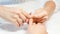 A person gets nails done. Hands closeup, vertical view