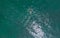 Person gracefully surfs the waves on a surfboard from a breathtaking aerial perspective